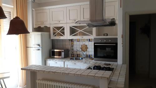 a kitchen with white cabinets and a counter top at Gemma's Apartment in Sarzana