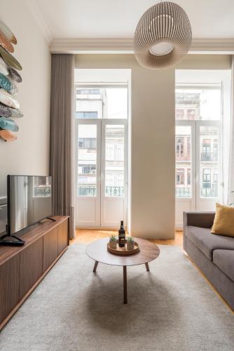a living room with a couch and a coffee table at Lit Apartments - SÁ DA BANDEIRA in Porto