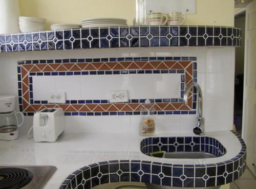 a kitchen with blue and white tiles on the wall at Posada Colonial Beach Villas in San Juan