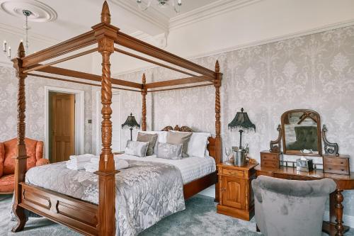 a bedroom with a canopy bed and a mirror at The Queens Hotel in Lytham St Annes