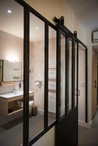 a bathroom with a sink and a mirror at Pont du Chalon Hôtel and Restaurant in Margès