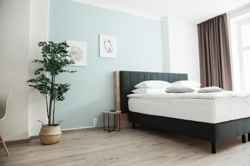 a bedroom with a bed and a potted plant at HONEST Smichov in Prague