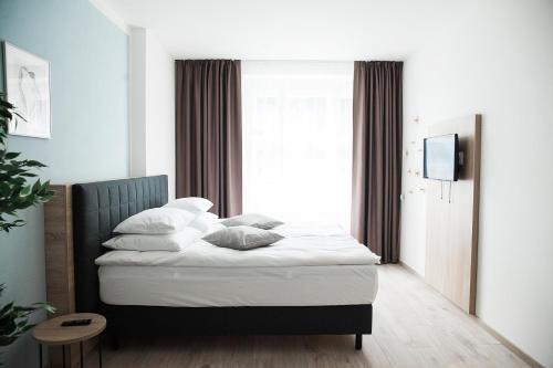 a bedroom with a bed with white sheets and pillows at HONEST Smichov in Prague