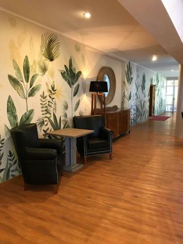 a room with chairs and a table and a wall with plants at CATANGE HOTEL in Charata