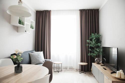 a living room with a dining room table and a television at HONEST Smichov in Prague
