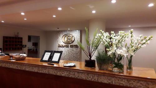 a reception desk with white flowers on top of it at CATANGE HOTEL in Charata
