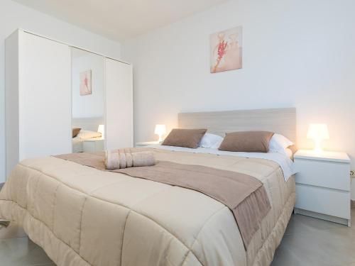 a large bed in a white room with two lamps at Apartment Vita in Poreč