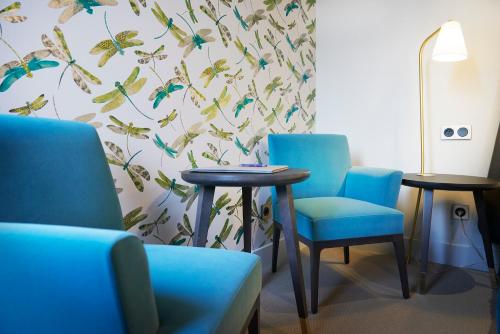 a waiting room with two tables and blue chairs at Pont du Chalon Hôtel and Restaurant in Margès