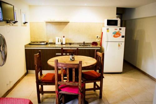 a kitchen with a table and a white refrigerator at Cabañas Sottobosco in Las Gaviotas