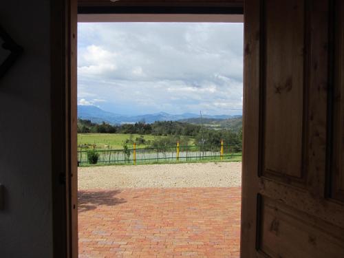 an open door with a view of a field at Ecohotel, Finca Colinas y Senderos in Paipa