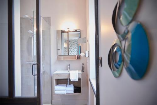 a bathroom with a sink and a mirror at Pont du Chalon Hôtel and Restaurant in Margès