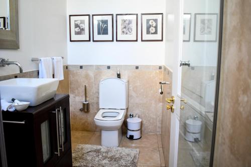 a bathroom with a white toilet and a sink at 20 ON WOODLANDS in Johannesburg