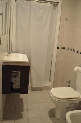 a bathroom with a toilet and a sink and a shower at Destino Real Hotel in Buenos Aires