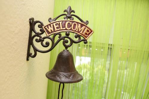 a bell hanging on a wall with a welcome sign at Elia in Skála Foúrkas