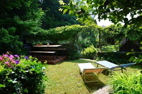 a garden with a picnic table and a bench at VALLE FIORITA 42 - Lake view apartment in Gardone Riviera