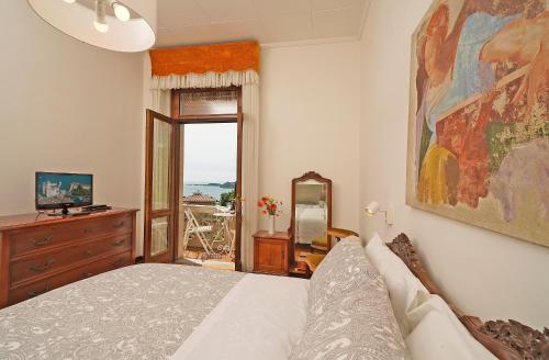 een slaapkamer met een bed, een dressoir en een raam bij VALLE FIORITA 42 - Lake view apartment in Gardone Riviera