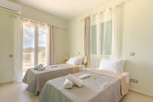 a bedroom with two beds and a large window at The Leaf House - Kefalonia in Lixouri