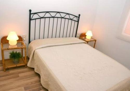a bedroom with a bed with two lamps on two tables at Cantilmar CALA FONT in Salou