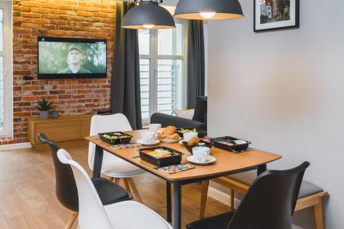een eetkamer met een tafel met eten erop bij Barbakan Residence Old Town in Krakau