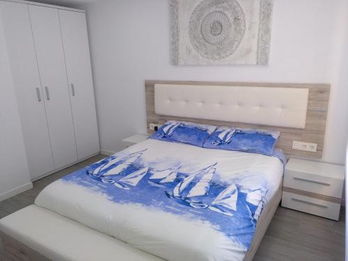a bedroom with a bed with blue and white sheets at Luxury CAP SALOU with POOL & BARBECUE & WIFI in Salou