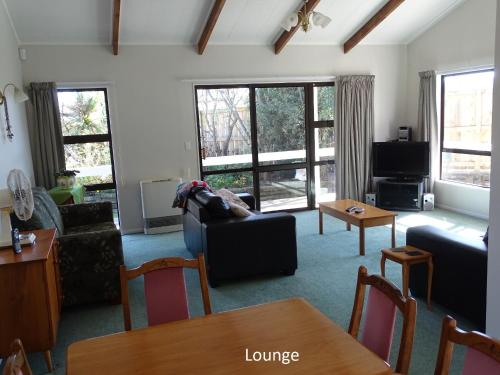 a living room with a couch and a table at Cabourne Cottage in Hamilton