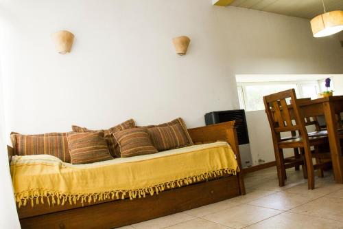a bedroom with a bed with a yellow blanket at Cabañas Sottobosco in Las Gaviotas