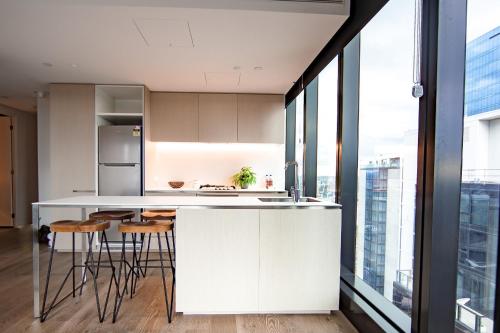 a kitchen with a table and a refrigerator at Australia 108 in Melbourne