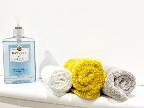 a bottle of laundry detergent and towels on a bathroom shelf at The Birches in Cambridge