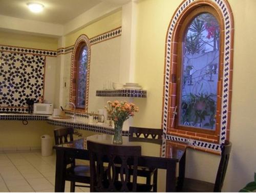 a dining room with a table with chairs and a window at Posada Colonial Beach Villas in San Juan