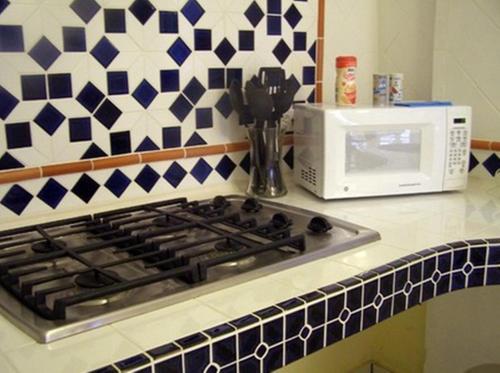 a stove top oven sitting next to a microwave at Posada Colonial Beach Villas in San Juan