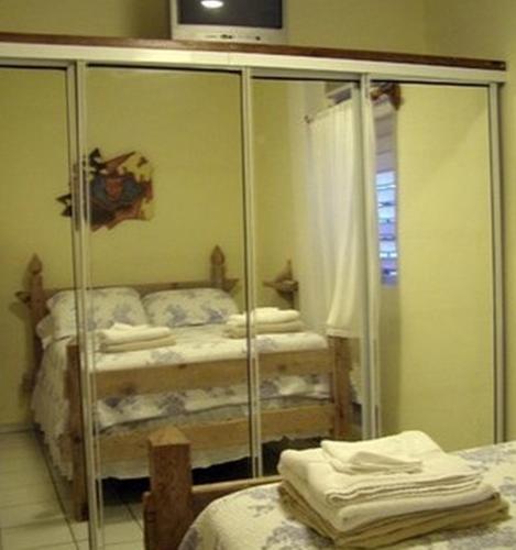 a bedroom with a glass closet with two beds at Posada Colonial Beach Villas in San Juan