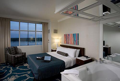 a hotel room with a bed and a bath tub at Bally's Evansville Casino & Hotel in Evansville