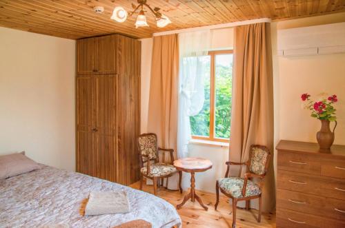 1 dormitorio con 1 cama, 2 sillas y ventana en The River House en Anykščiai