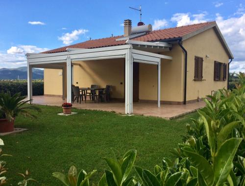 a detached house with a patio and a table at Il Giardino in Riotorto