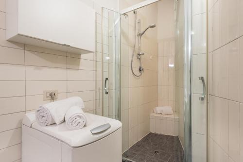 San Frediano flat nice view في فلورنسا: حمام أبيض مع دش ومرحاض