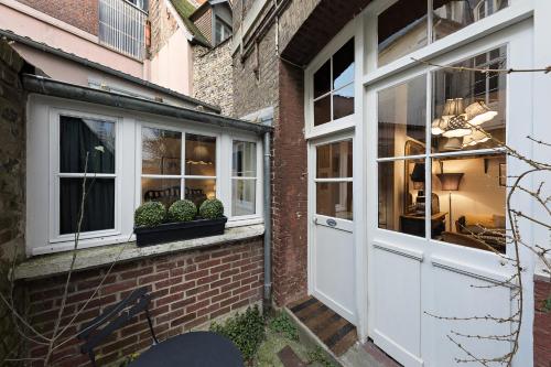 a brick building with a white door and windows at Les Petites Suites Dieppoises - L'Atelier Couture in Dieppe