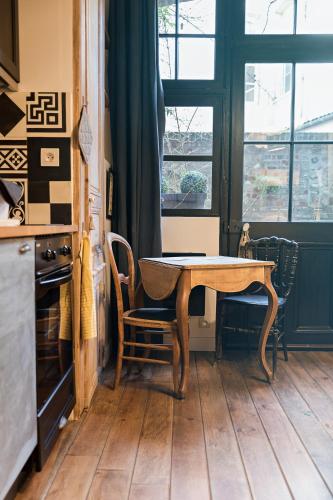 une table et des chaises dans une cuisine avec une fenêtre dans l'établissement Les Petites Suites Dieppoises - L'Atelier Couture, à Dieppe