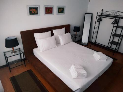 a bedroom with a bed with white sheets and pillows at Espreit'ómar - SeaPeek in Setúbal