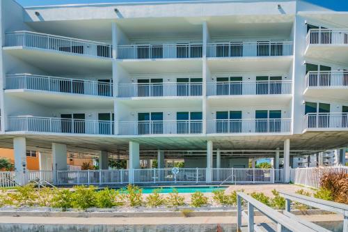 an apartment building with a pool in front of it at Provident Oceana Beachfront Suites in St Pete Beach