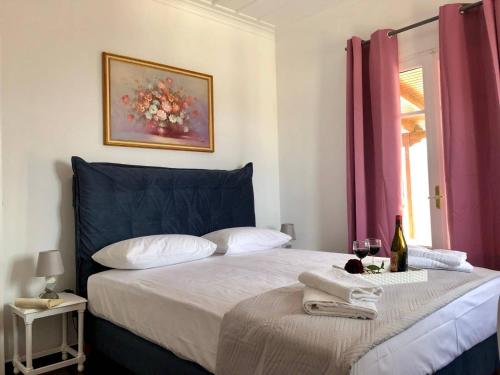 - une chambre avec un lit doté d'une tête de lit bleue et d'une fenêtre dans l'établissement Neoclassical mansion with view and garden, à Andros