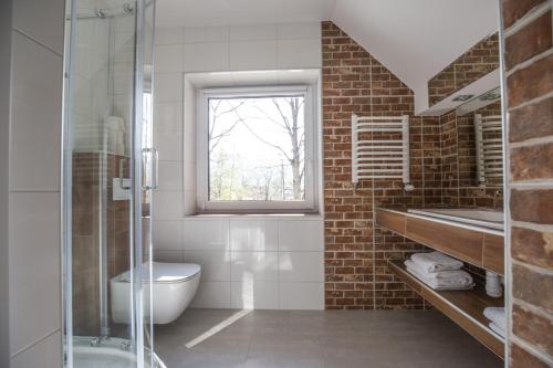 a bathroom with a toilet and a sink and a window at Pokoje Na Szlaku in Lądek-Zdrój