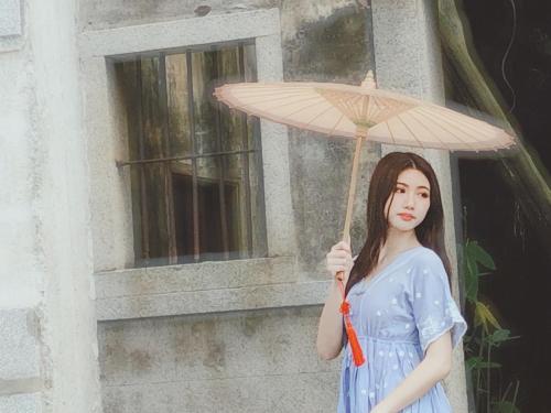 a woman in a blue dress holding an umbrella at 依山行館 浪漫恬靜的落腳處 in Jincheng