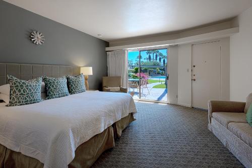 a bedroom with a bed and a couch and a window at Desert Hills in Palm Springs