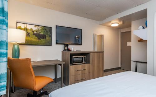 a hotel room with a desk and a tv at Bridgewater Hotel, Trademark Collection by Wyndham in Fairbanks