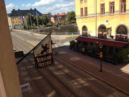 un letrero para un hotel de pie en una calle en Strand Hotel, en Norrköping