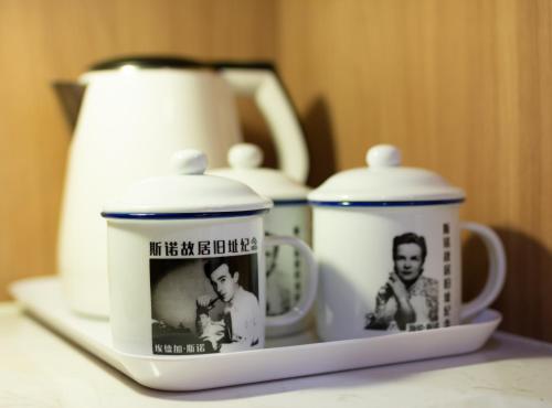 a shelf with three cups and a tea kettle at Zhong An Hotel Beijing in Beijing