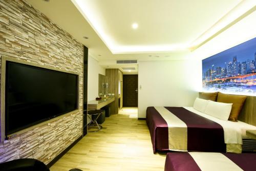 a hotel room with a large tv and a bed at ZJ Motel in Hsinchu City