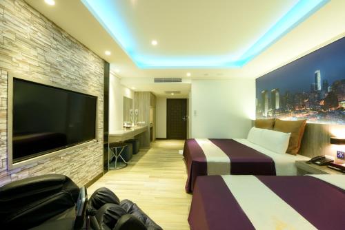 a hotel room with two beds and a flat screen tv at ZJ Motel in Hsinchu City