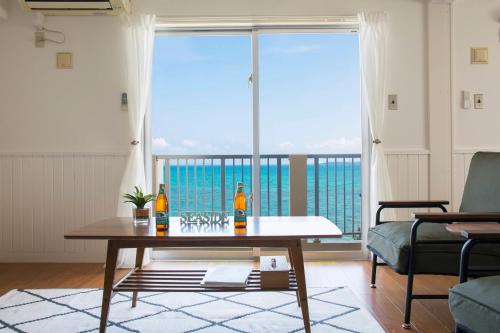 a living room with a table and a view of the ocean at Fortuna YAKA in Kin
