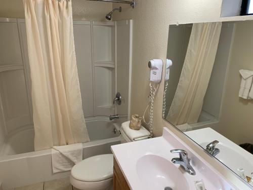 y baño con lavabo, aseo y espejo. en Seaview Inn Grover Beach en Grover Beach